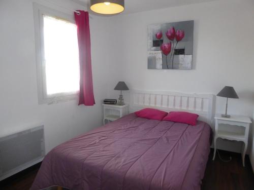 - une chambre avec un lit violet et 2 oreillers roses dans l'établissement Appartement Cosy avec Piscine, près du Lac de Tanchet et Plages, Les Sables-d'Olonne - FR-1-325-129, à Les Sables-dʼOlonne