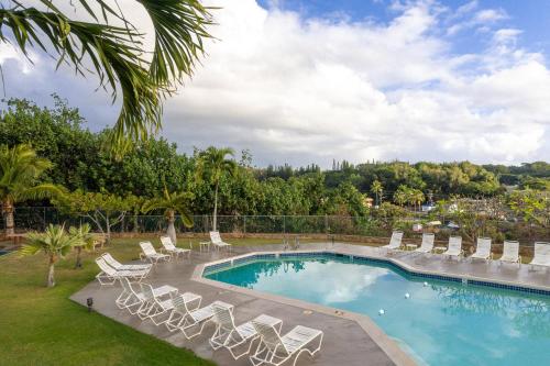 a swimming pool with lounge chairs and a resort at Banyan Harbor Resort in Lihue