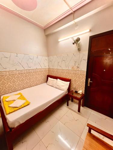 a small bedroom with a bed and a door at Cao Nguyên Xanh in Bao Loc