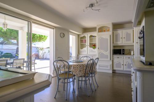 Una cocina con una mesa y sillas en una cocina. en Beautiful family house with a large terrace, en Saint-Martin-de-Ré