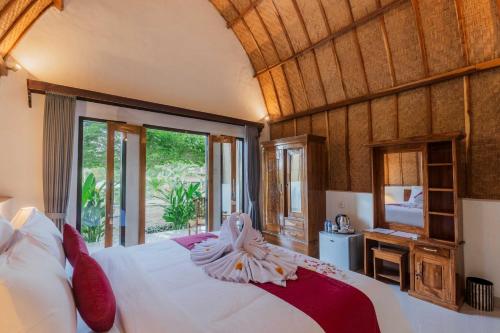 a bedroom with a large bed and a television at Jewel of Penida in Nusa Penida
