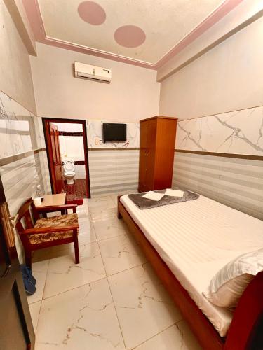 a bedroom with a bed and a table and a tv at Cao Nguyên Xanh in Bao Loc