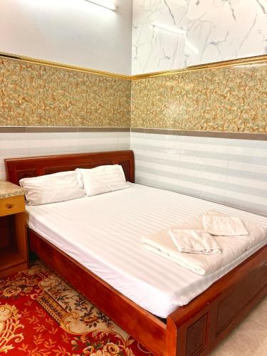 a bedroom with a bed with white sheets at Cao Nguyên Xanh in Bao Loc