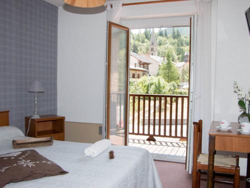 1 dormitorio con cama y vistas a un balcón en Le Guilazur en Château-Ville-Vieille