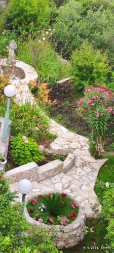 a garden with a stone pathway with flowers and plants at Riviera Rooms and Apartments in Rab
