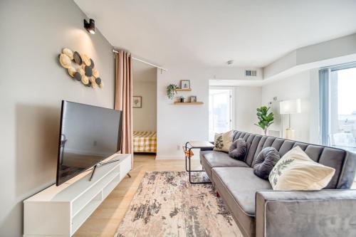 a living room with a couch and a flat screen tv at Yorkville Plaza Express Stay in Toronto