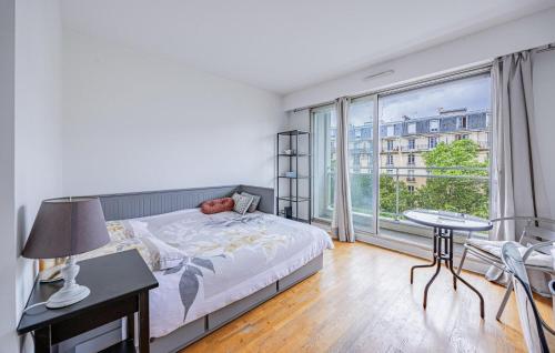 une chambre avec un lit et une grande fenêtre dans l'établissement Cozy Apartment In Paris With Kitchen, à Paris