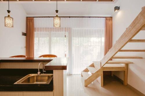 a kitchen with a sink and a stair case at Villa Istha Puri 2 in Ketewel