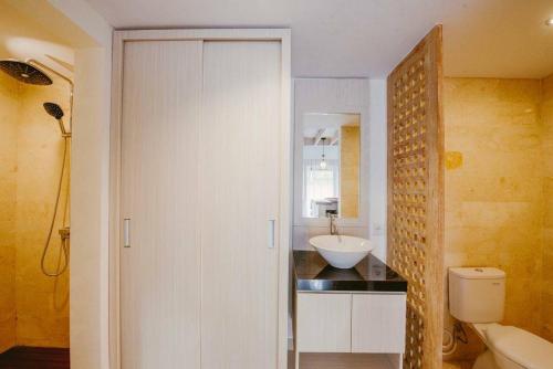 a white bathroom with a sink and a toilet at Villa Istha Puri 2 in Ketewel