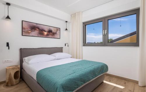 a bedroom with a bed and a large window at Beautiful Apartment In Omisalj in Omišalj