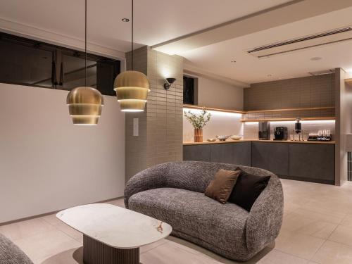 a living room with a couch and a table at Sunhotel Fukuyama in Fukuyama