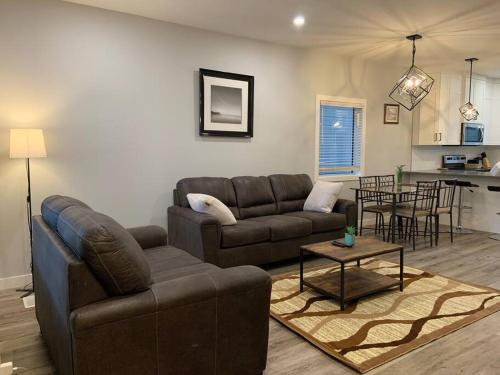 a living room with a couch and a table at Exquisite 3 BR Villa with Double Garage-King Bed in Regina