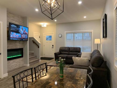 a living room with a couch and a table at Exquisite 3 BR Villa with Double Garage-King Bed in Regina