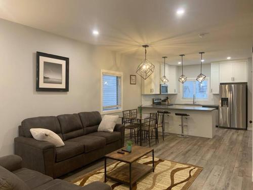 a living room with a couch and a kitchen at Exquisite 3 BR Villa with Double Garage-King Bed in Regina