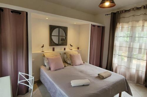 une chambre avec un lit avec deux serviettes dessus dans l'établissement Villa Olmeccia piscine 14 m, clim, plein Sud, à Porto-Vecchio