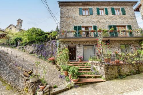 a brick house with potted plants on the steps at Locanda Senio in Palazzuolo sul Senio