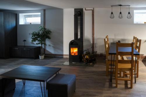 a living room with a fireplace and a table and chairs at Apartmán Na Stezce in Stará Červená Voda