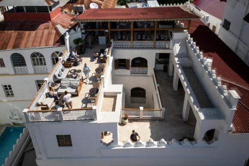 uma vista superior de um edifício com pessoas sentadas na varanda em The Neela Boutique Hotel Stone Town em Zanzibar City