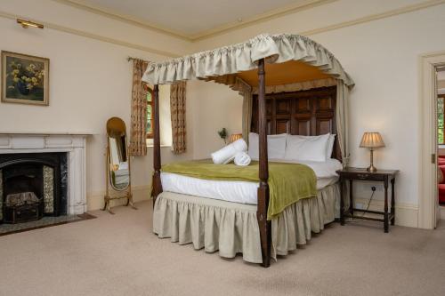 Un dormitorio con una cama con dosel y una chimenea. en Watermouth Castle, Clock Tower Apartment, en Ilfracombe