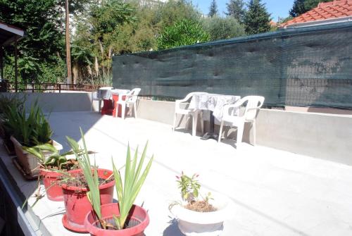a patio with chairs and tables and potted plants at Sunshower apartment and studio in Split