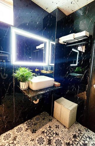 a bathroom with a white sink and a blue wall at Rosa Hotel & Spa in Ho Chi Minh City