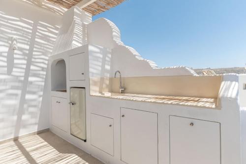a kitchen with white cabinets and a sink at Deco Suites in Naxos Chora