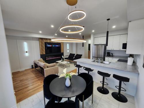 a kitchen and living room with a table and chairs at Exclusive Home in Niagara Falls in Thorold