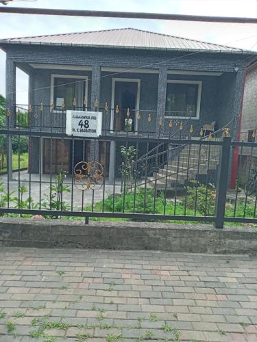 a fence in front of a house with a balcony at Надежда in K'obulet'i