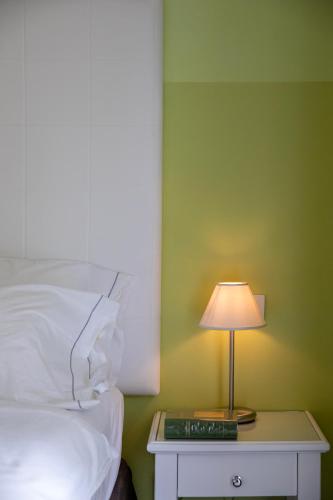 a bed with a table with a lamp on it at Palace Hotel San Pietro in Bardolino
