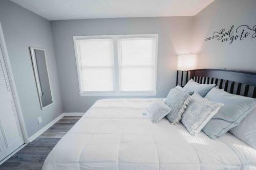 a white bedroom with a large white bed with pillows at Hot Tub, Pool table, Sleeps 10 in Lexington