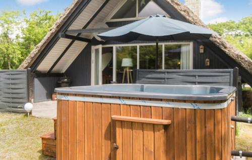 a hot tub in front of a house with an umbrella at 3 Bedroom Lovely Home In Hemmet in Hemmet