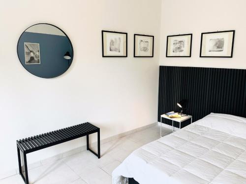 a bedroom with a bed and a mirror on the wall at Sophie's Moderno vista Duomo in Massa Marittima