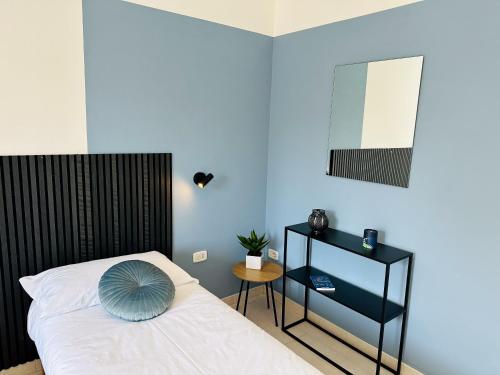 a bedroom with a white bed and a blue wall at Sophie's Moderno vista Duomo in Massa Marittima