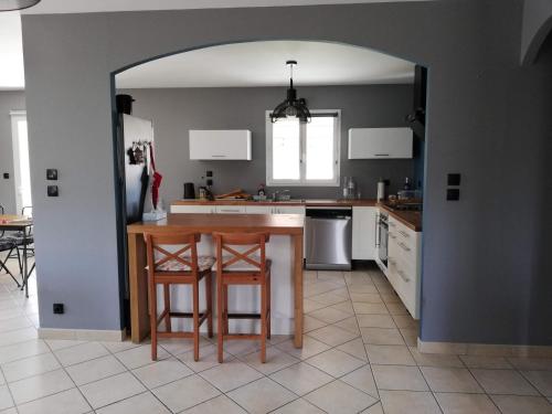 une cuisine avec une table et deux tabourets dans l'établissement Villa victoria, à Cornillon