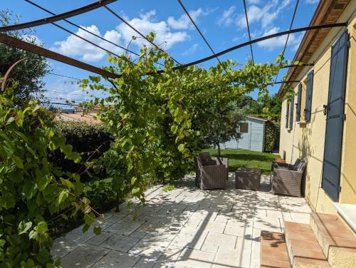 un patio avec des chaises et un bouquet de vigne dans l'établissement Villa victoria, à Cornillon