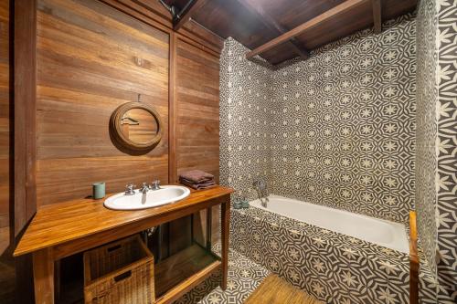a bathroom with a sink and a bath tub at The Fern Lodge in Bedugul