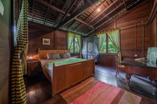 a bedroom with a bed in a room with wooden walls at The Fern Lodge in Bedugul