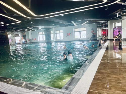 a group of people swimming in a swimming pool at HT Home D'el Dorado 1 in Hanoi