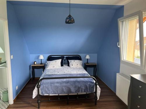 - une chambre bleue avec un lit aux murs bleus dans l'établissement Chez Catherine, à Branville