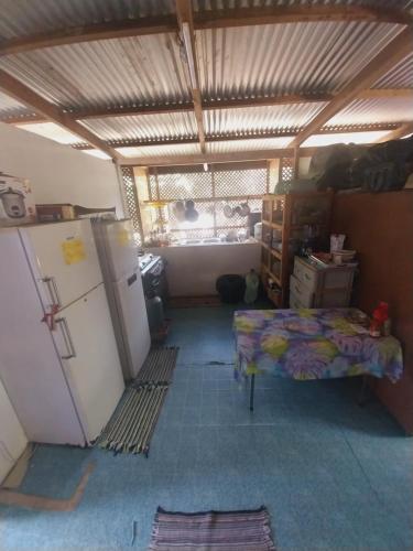 Zimmer mit einem Kühlschrank und einem Bett. in der Unterkunft Tapuhere Lodge in Fare
