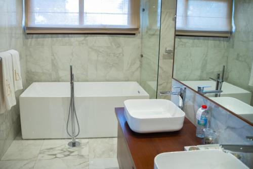 a bathroom with a tub and a sink and a bath tub at La Varangue in Antananarivo