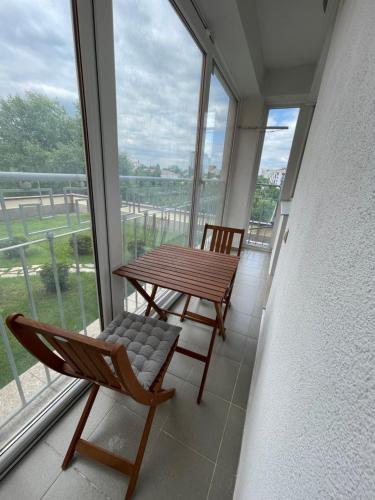 a balcony with a wooden table and a chair at Spacious apartment close to Valea Trandafirelor park! in Chişinău