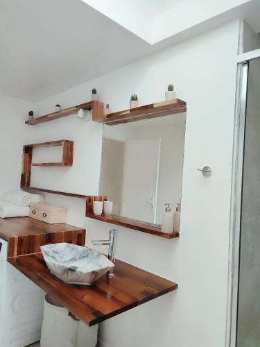 La salle de bains est pourvue d'une table en bois et d'un miroir. dans l'établissement Idéale pour ouvriers, proche d'Antony, Massy et Versailles, à Bièvres