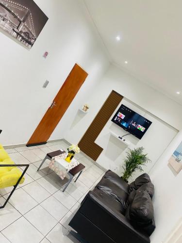 a living room with a couch and a tv at Airport Royal Guest House in Kempton Park