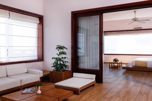 a living room with a couch and a bed at Gokulam Grand Turtle On The Beach in Kovalam