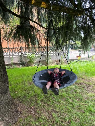 a boy laying on a trampoline under a tree at Villa 2 in Cassano dʼAdda
