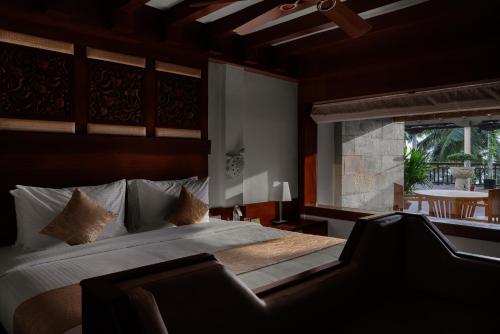 a bedroom with a large bed and a window at Gokulam Grand Turtle On The Beach in Kovalam