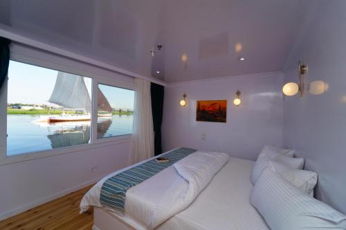 a bedroom with a bed and a large window at Turquoise in Luxor