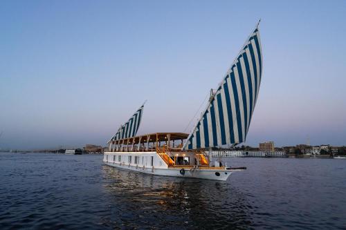 a boat with blue and white sails on the water at Turquoise in Luxor