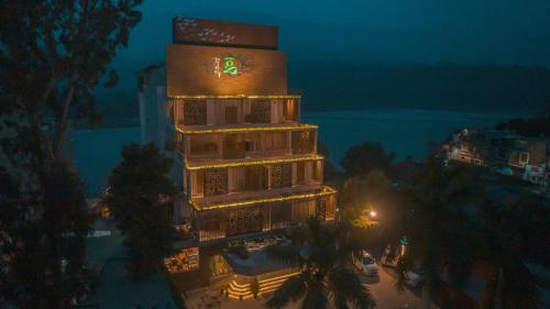 a tall building with a clock on it at night at GANGA KINARE- A Riverside Boutique Resort, Rishikesh in Rishīkesh